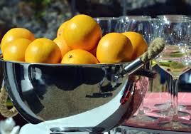 Saladier en métal avec des oranges, et verre de vin